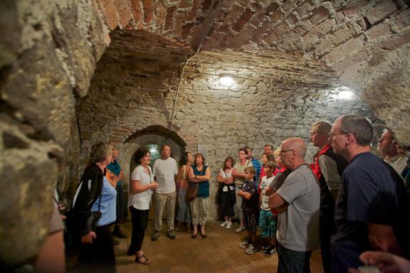 Gruppe von Menschen bei einer Führung in einem historischen Gewölbekeller mit Backsteinmauern und -decken im Braumuseum Torgau