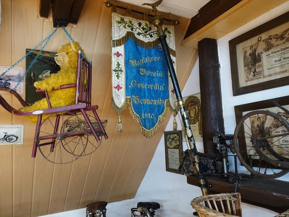 Spielzeugstuhl mit einem Bären und historischem Banner in einer Ausstellung